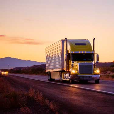 Shipping from Washington to California - Truck on road at sunset