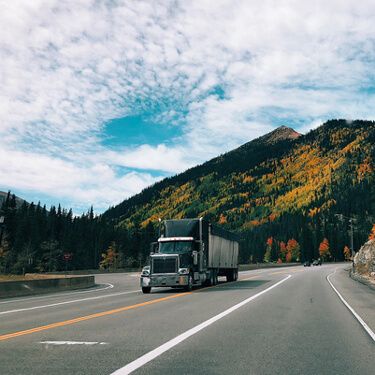 shipping-freight-from-maine-to-california-black-semi-truck-mountains