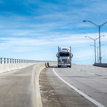 single semi-truck crossing bridge in route from Michigan to Texas